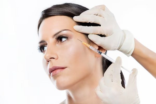 beautiful young woman getting botox cosmetic injection in her face.