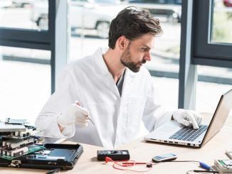 Young male technician using laptop in workshop. Top 3 Computer Repair Places in Mexico City