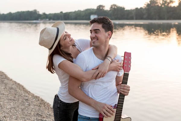 Attractive couple walking lake guitar - places to go as a couple