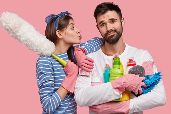 Fatigue indifferent man shaving holds many bottles detergent his wife leans on shoulder wants to kiss her cheek holds duster 