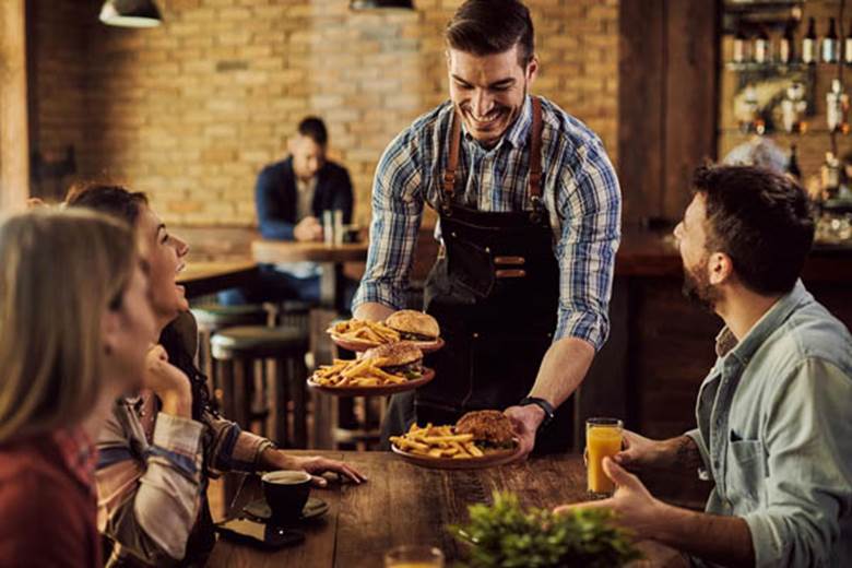 happy-waiter-serving-food-group-happy-friends-pub